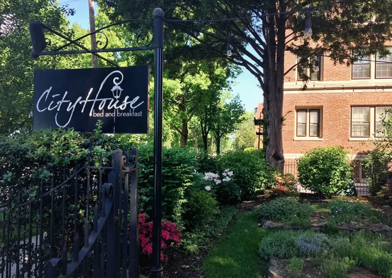 Business sign and garden on the foreground with a cropped view of the building in the back.